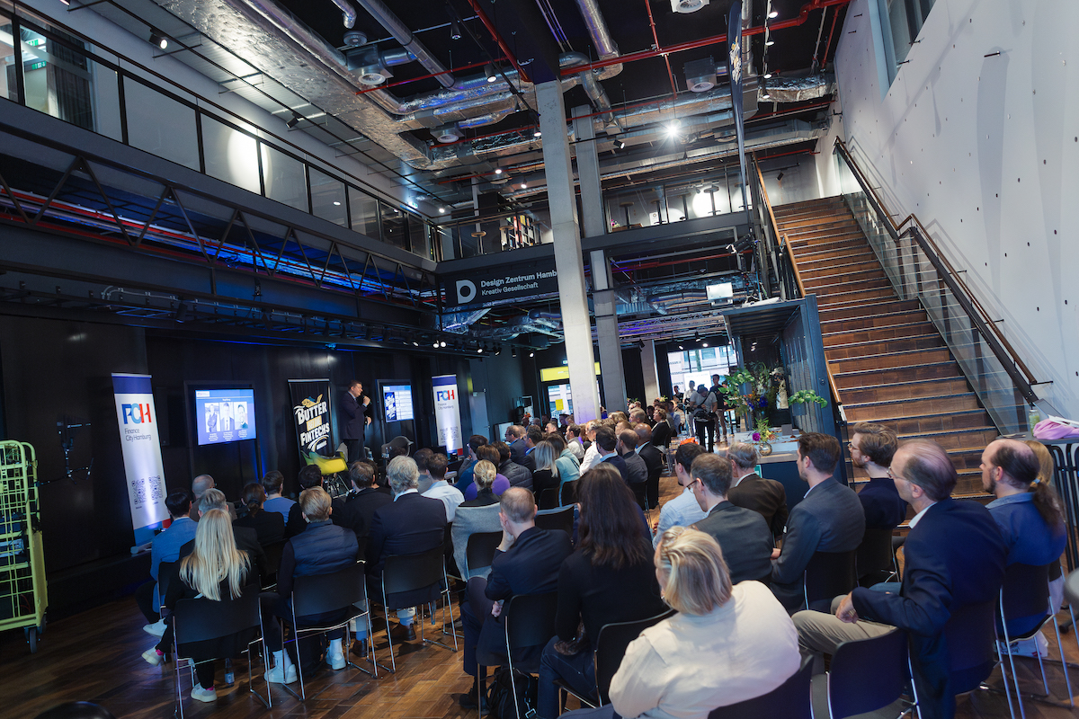 People look at a stage during Hamburg Fintech Day 2024, Finance Senator Dr Andreas Dressel speaks