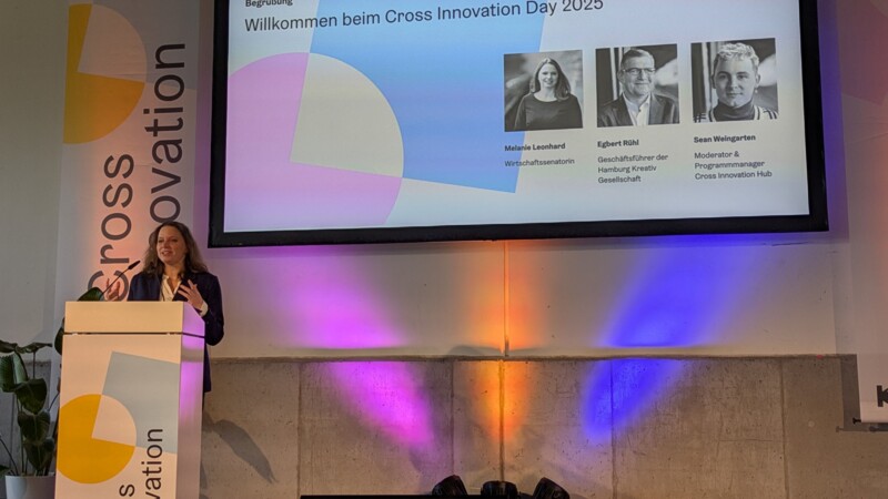 Senator for Economics and Innovation Melanie Leonhard during her opening speech on the stage, which is highlighted by colorful spotlights