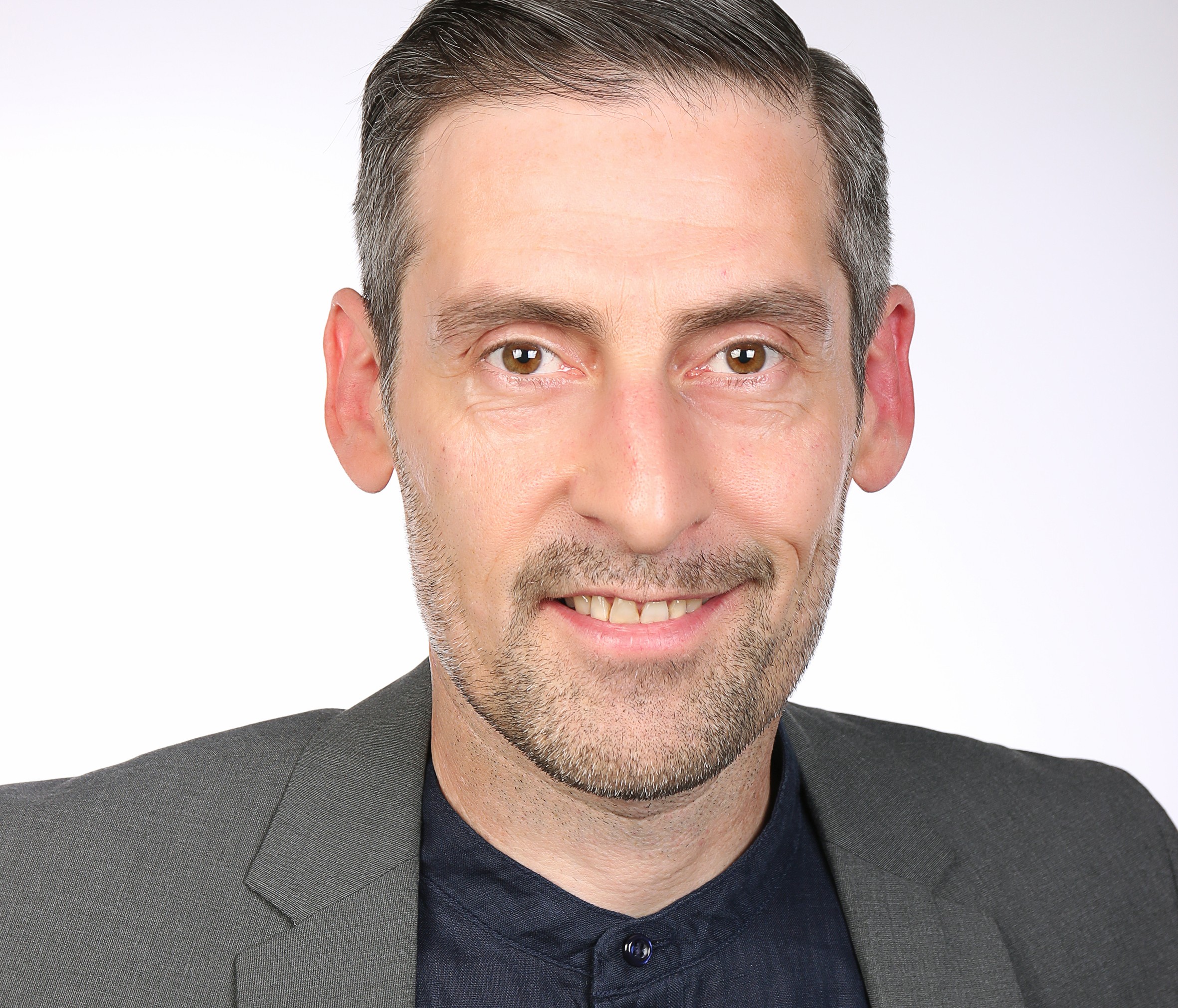 Porträt eines lächelnden Mannes mit kurzem Haar, Bart und grauem Sakko vor weißem Hintergrund: Alexander von Gablenz, Vorstand für Rettungstechnologie bei Humanilog