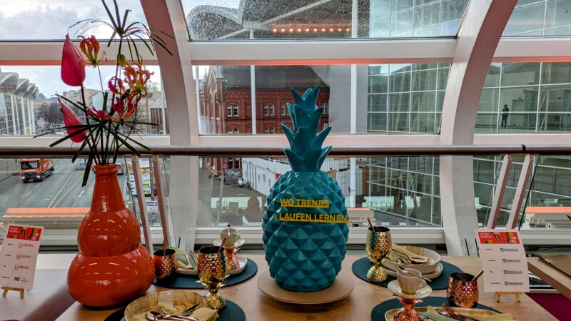 Tischdekoration mit Tellern, Besteck und einer blauen Ananas aus Porzelan