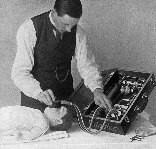 A man uses a historical respirator on a mannequin