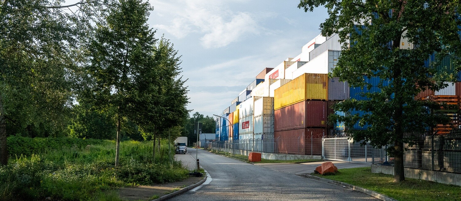 Site with a large number of containers on a leafy street