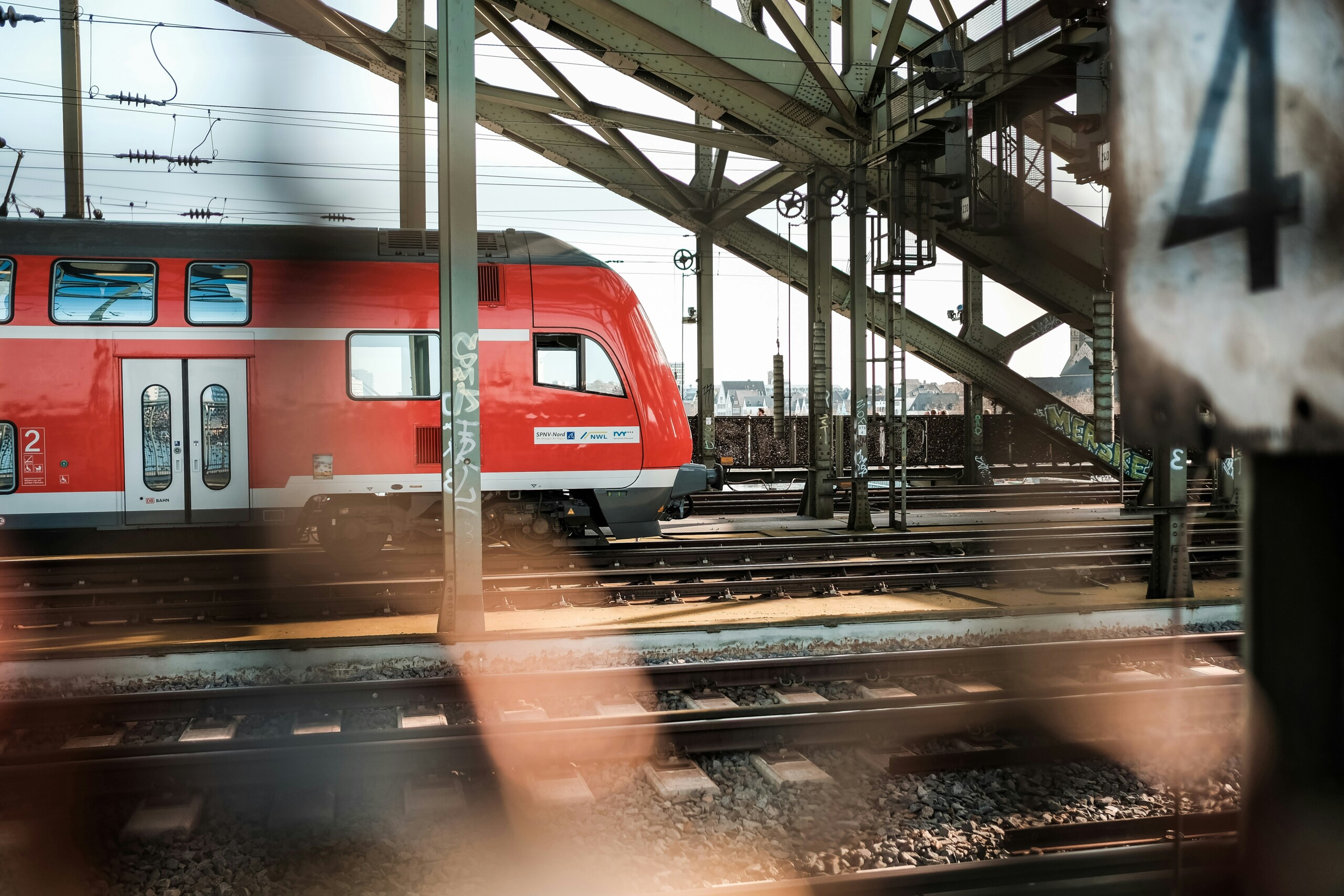 Roter Regionalzug fährt über Brücke