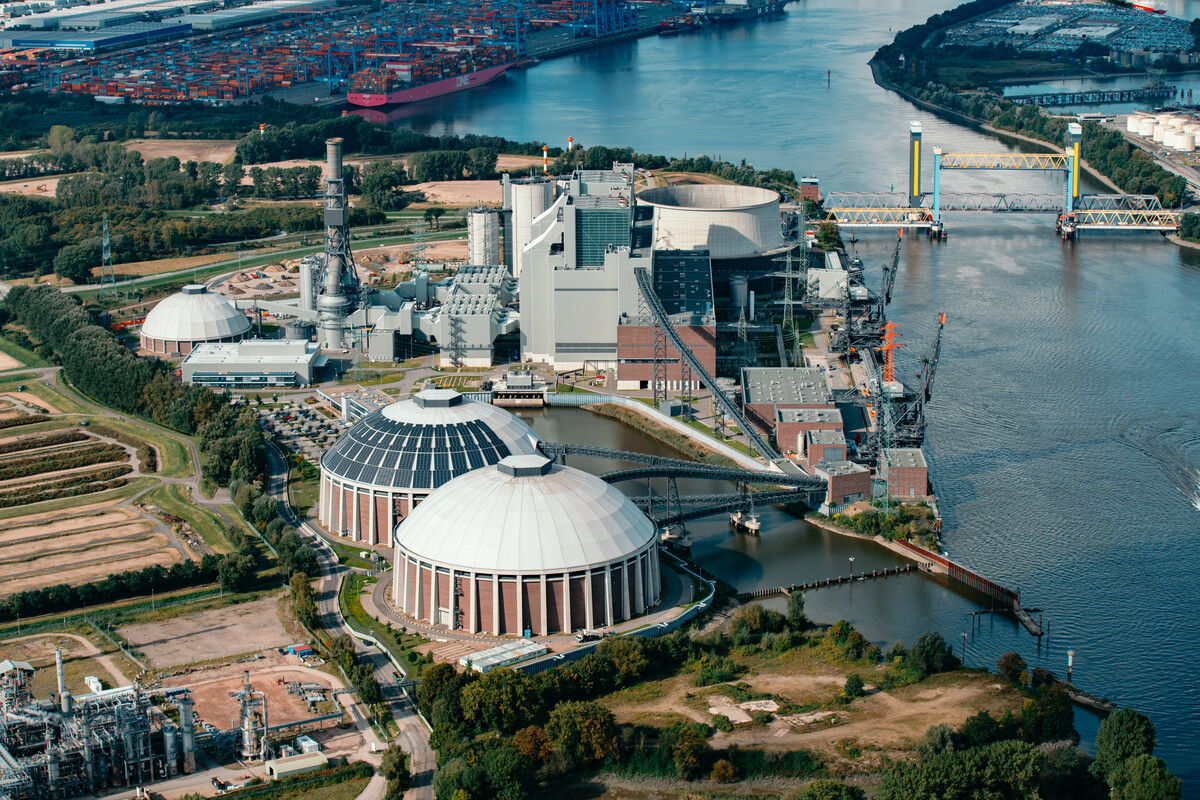 Aerial view of an industrial complex with cooling towers and port