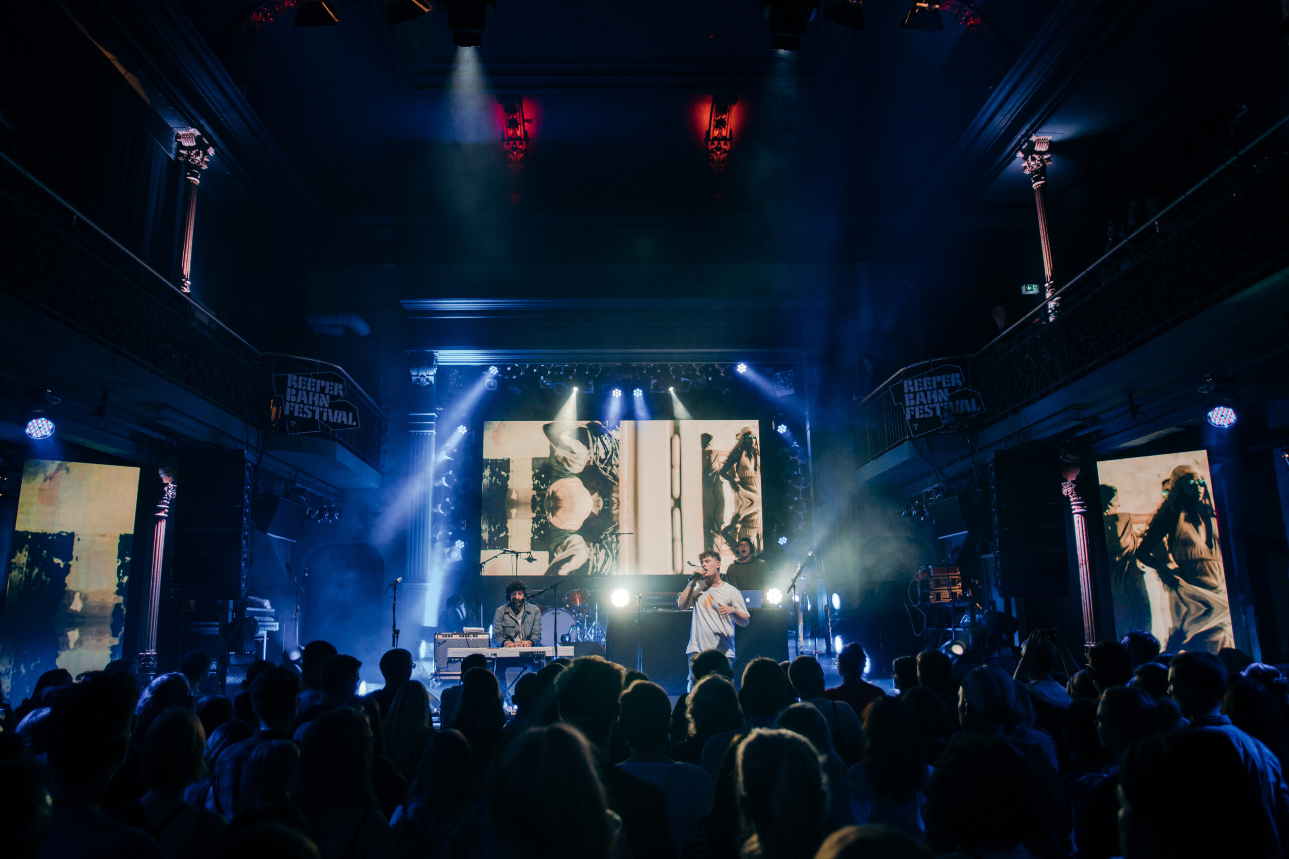 Konzert mit Sänger, Keyboarder und DJ vor großem Publikum und Videoleinwand im Reeperbahn Festival.