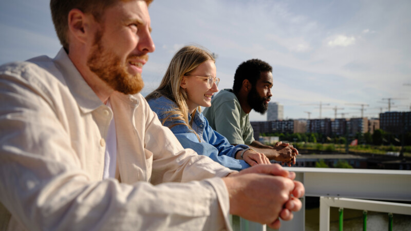  AIM Leaders Konferenz Symbolbild: "In die Zukunft", drei junge Menschen stehen auf einer Dachterasse in Hamburg und schauen noch vorne