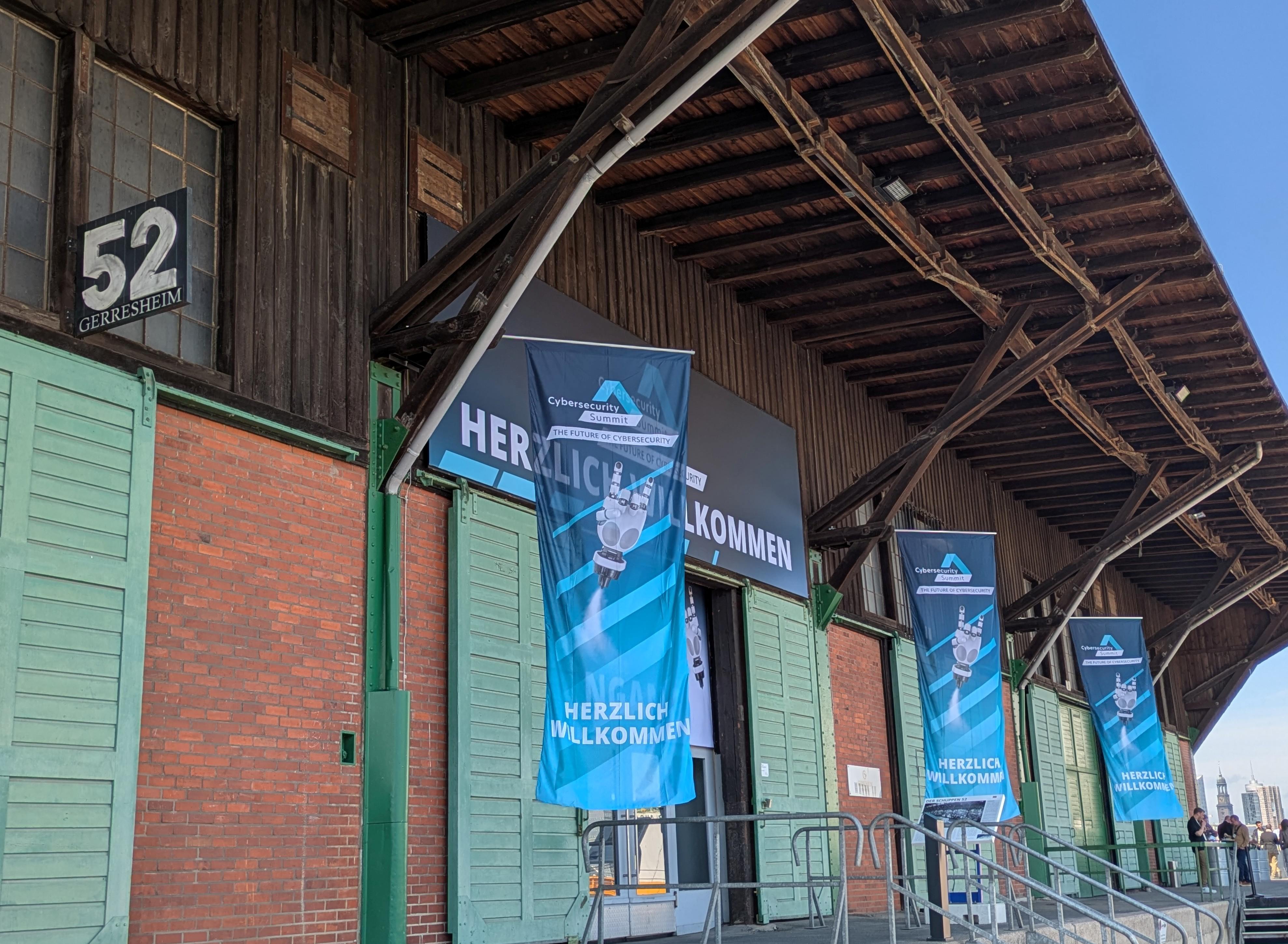 Außenansicht der Veranstaltungslocation Schuppen 52 mit Flaggen des Cybersecurity Summits