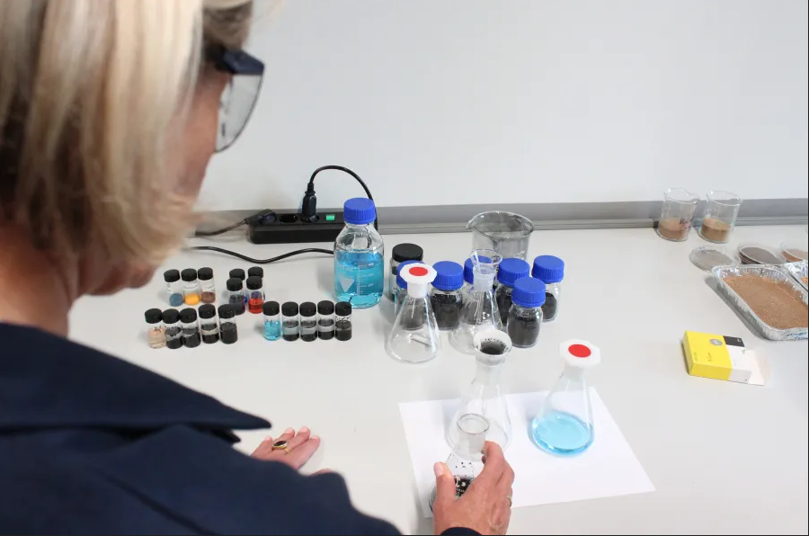 Scientist examines various chemical samples and solutions on a bench in laboratory