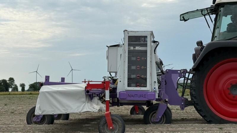 Farming machinery with electronic equipment, attached to a tractor in a field