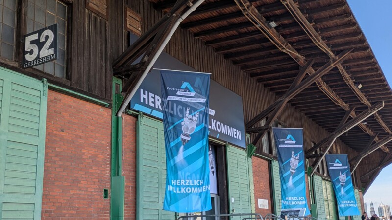 Außenansicht der Veranstaltungslocation Schuppen 52 mit Flaggen des Cybersecurity Summits
