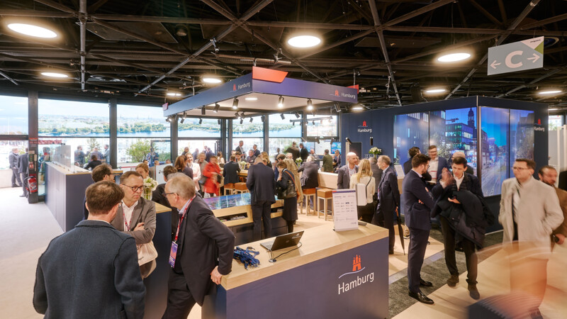 Geschäftsleute unterhalten sich am Hamburg Stand auf der MIPIM