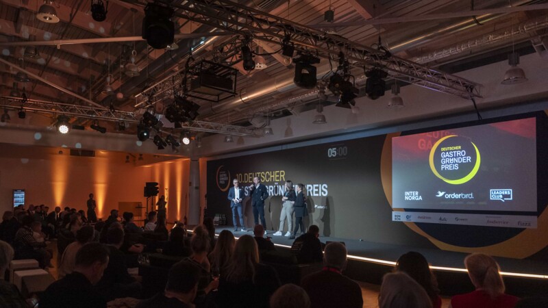 Preisverleihung des 10. Deutschen Gastro Gründerpreises mit Publikum und Rednern auf der Bühne.