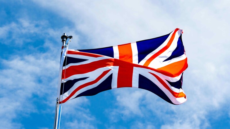 Eine britische Flagge weht im Wind vor blauem Himmel 