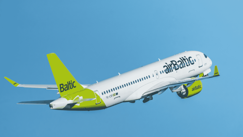 Passagierflugzeug der Fluggesellschaft airBaltic mit grünem Heck fliegt vor klarem blauem Himmel.