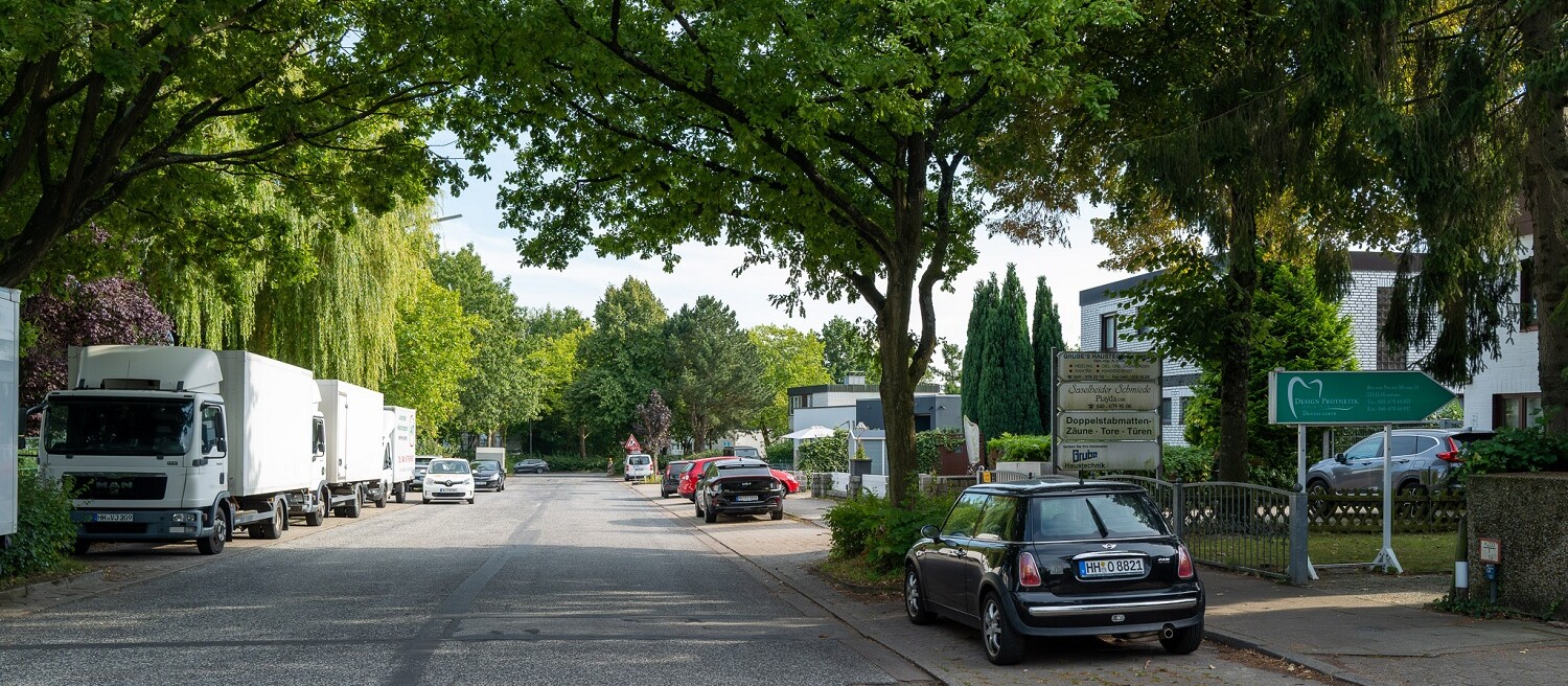 Road bordered by trees with parked lorries and cars at the Bargkoppelweg site