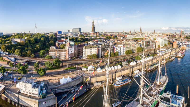 Panoramablick auf den Hamburger Hafen mit Schiffen, Elbphilharmonie und Stadt im Sonnenschein.