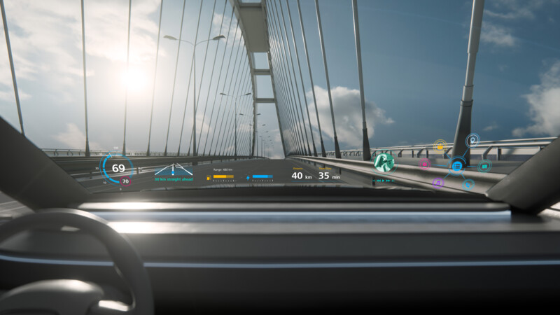 Blick durch die Windschutzscheibe eines Autos mit Head-up-Display auf einer Brücke bei Sonnenlicht