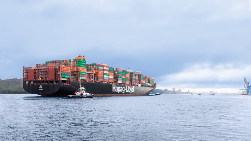 Containerschiff der Reederei Hapag-Lloyd bei Einfahrt in den Hamburger Hafen bei bewölktem Himmel