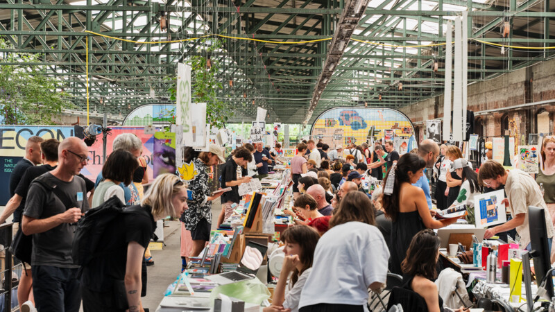 People at a bustling indoor art and book fair 