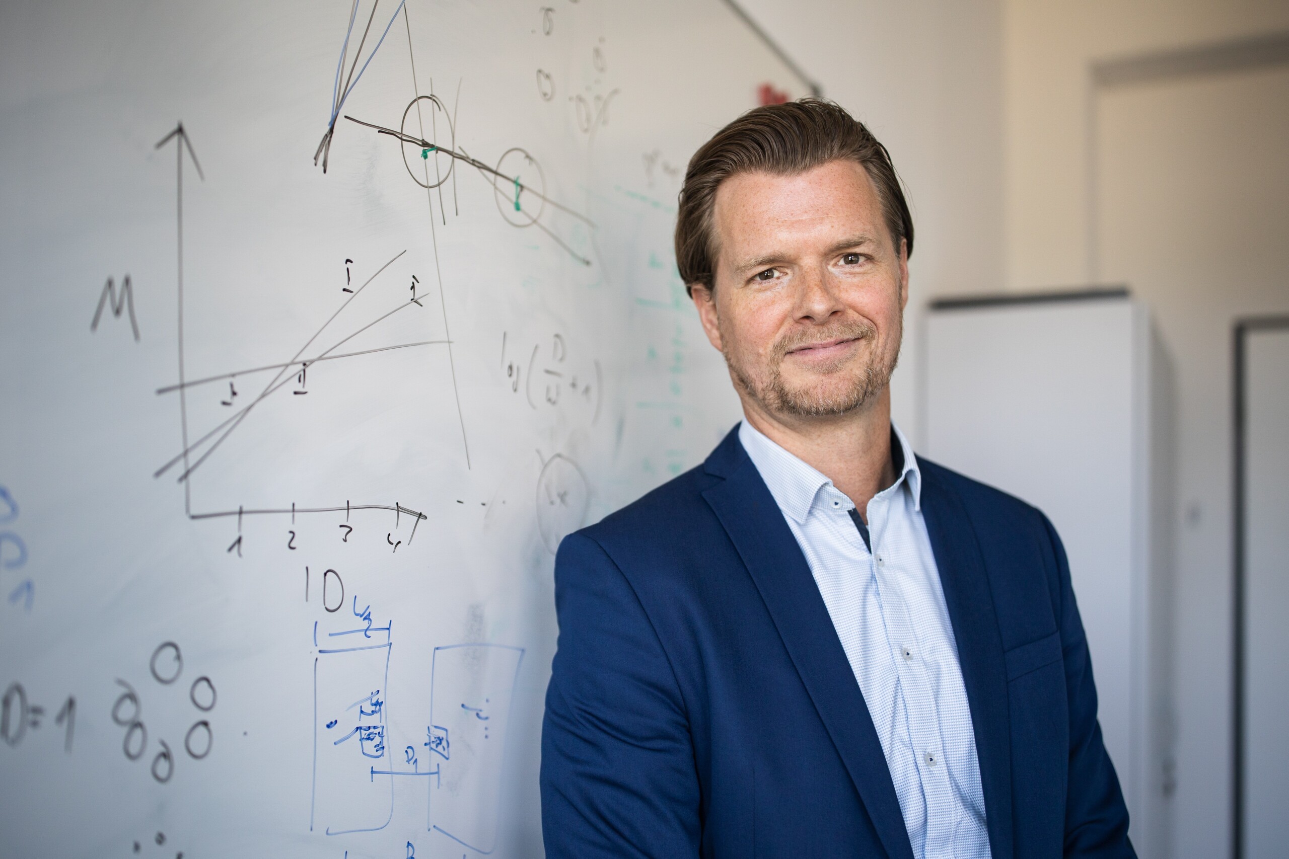 Technology realist Professor Frank Steinicke in front of a board with diagrams.