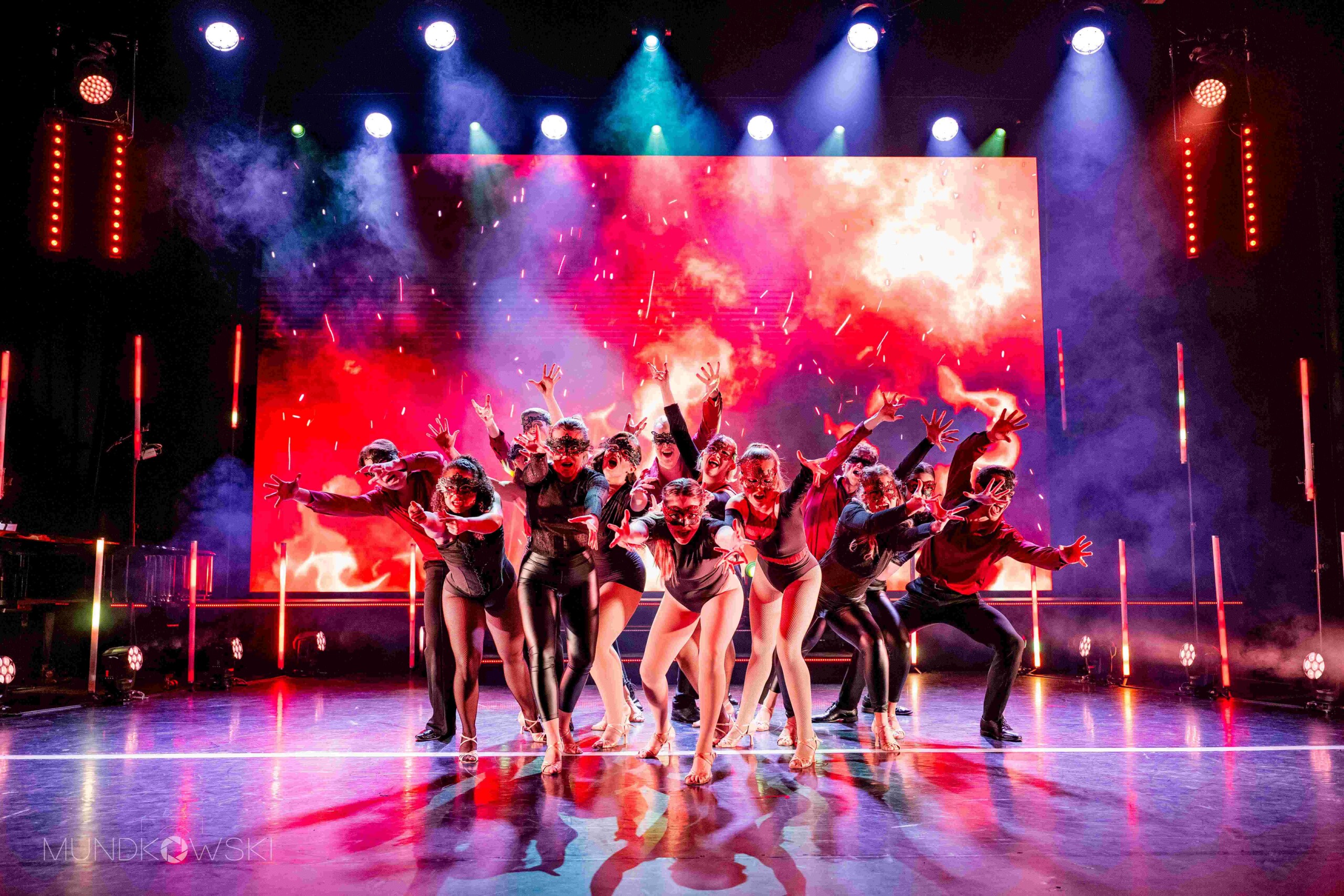 Masked performers on stage in "First Stage Theater"