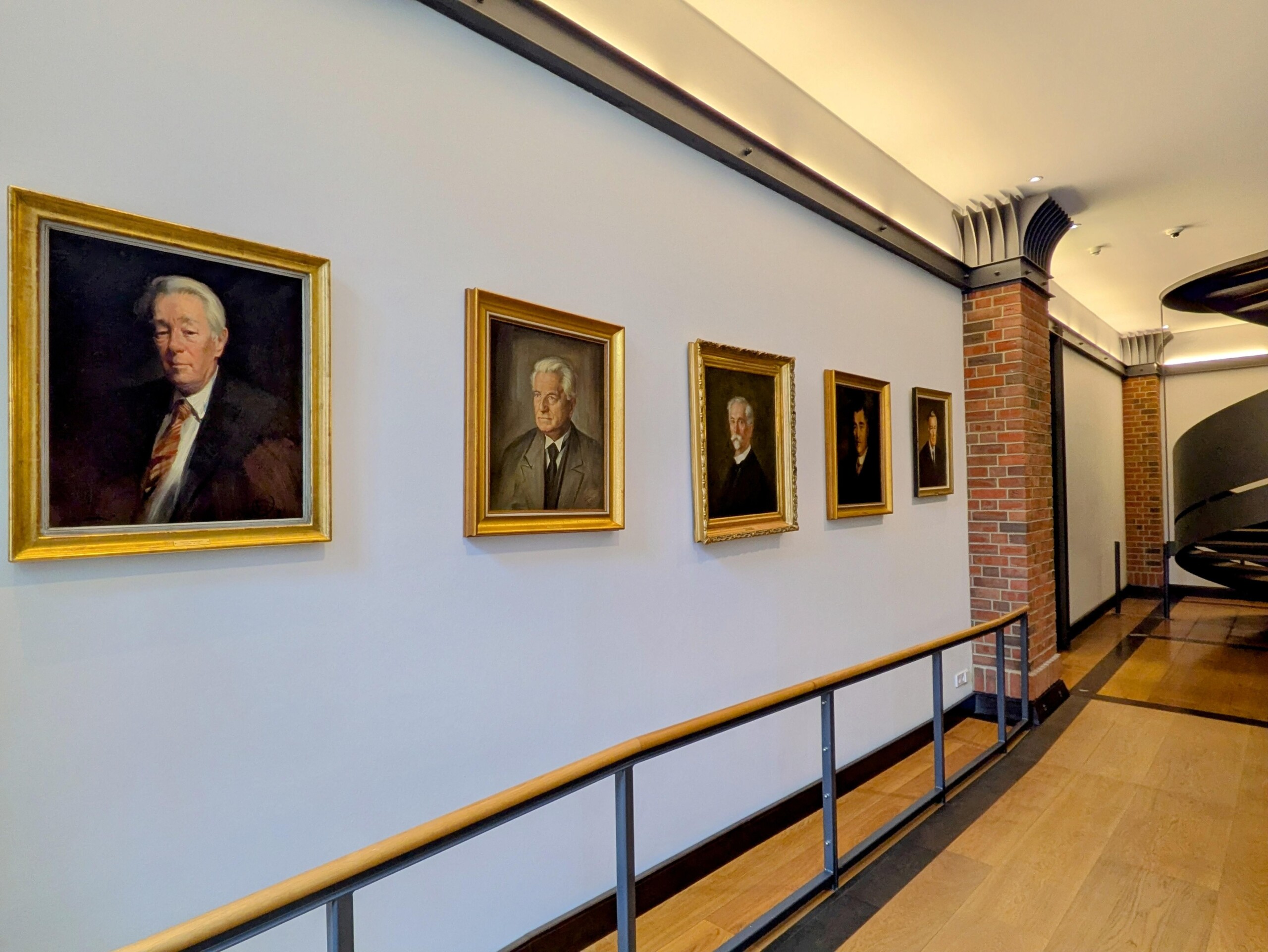Hall with five portraits and a spiral staircase
